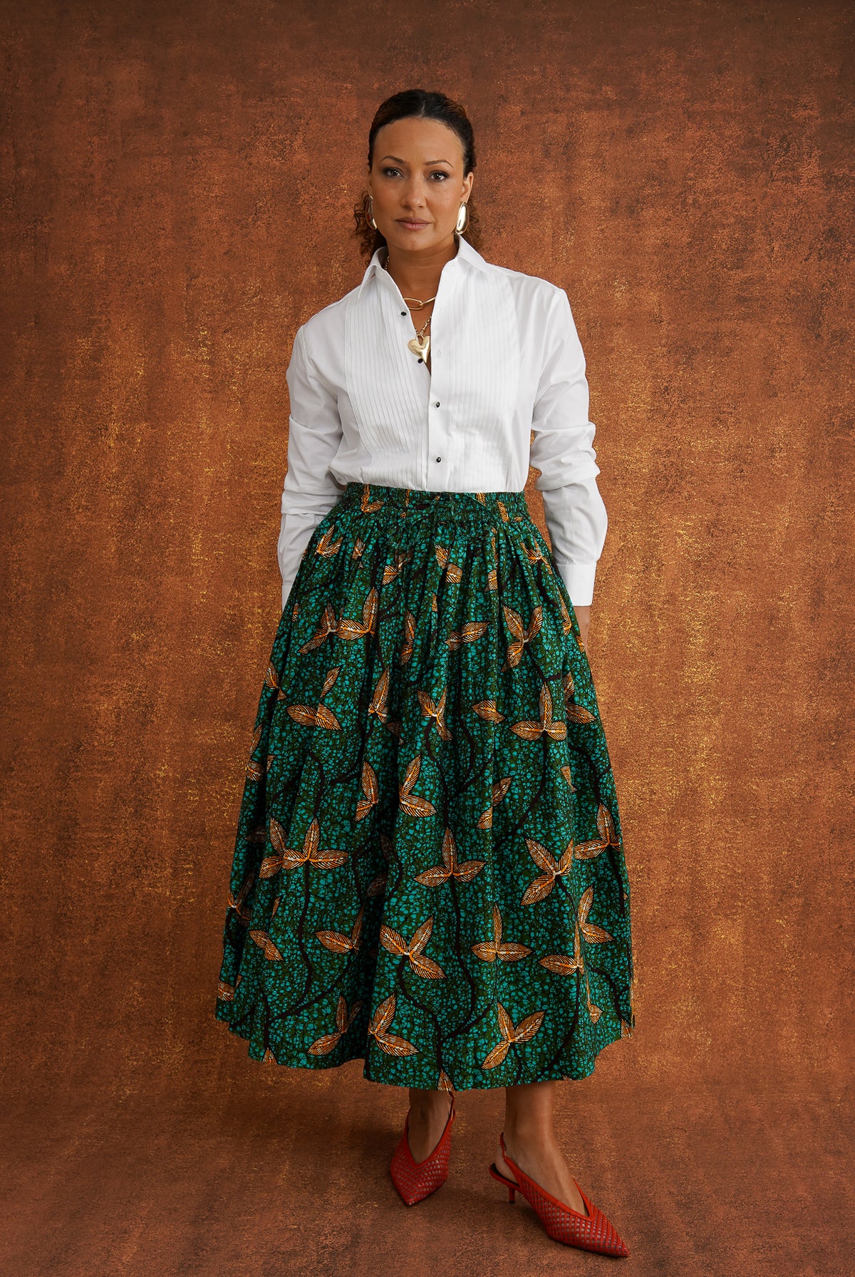 Front view of Tanna green Dutch wax cotton skirt styled with a tucked-in white shirt
