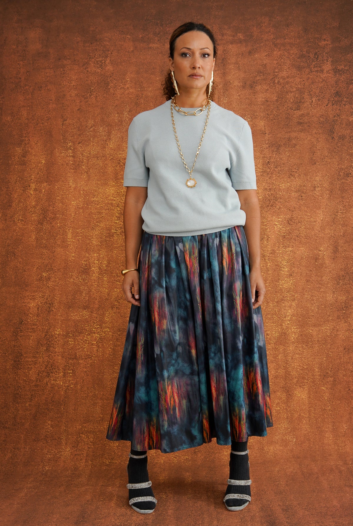 KemKem Abstract Midi Skirt in a bold abstract print of deep blues, purples, reds and oranges, with a patterned belt and metallic tips