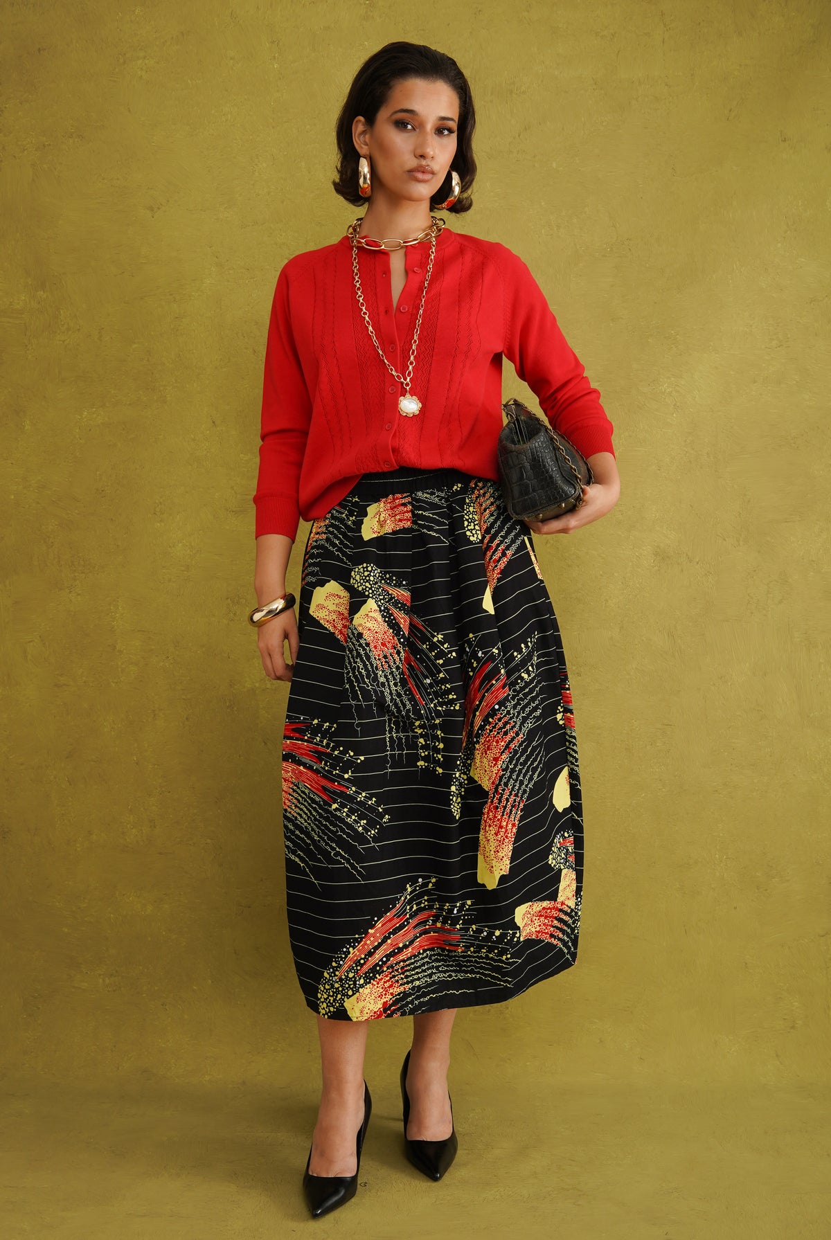 Titi Cardigan in Red, a relaxed-fit red knit cardigan with open-work and cable stitches and small buttons up to the neck