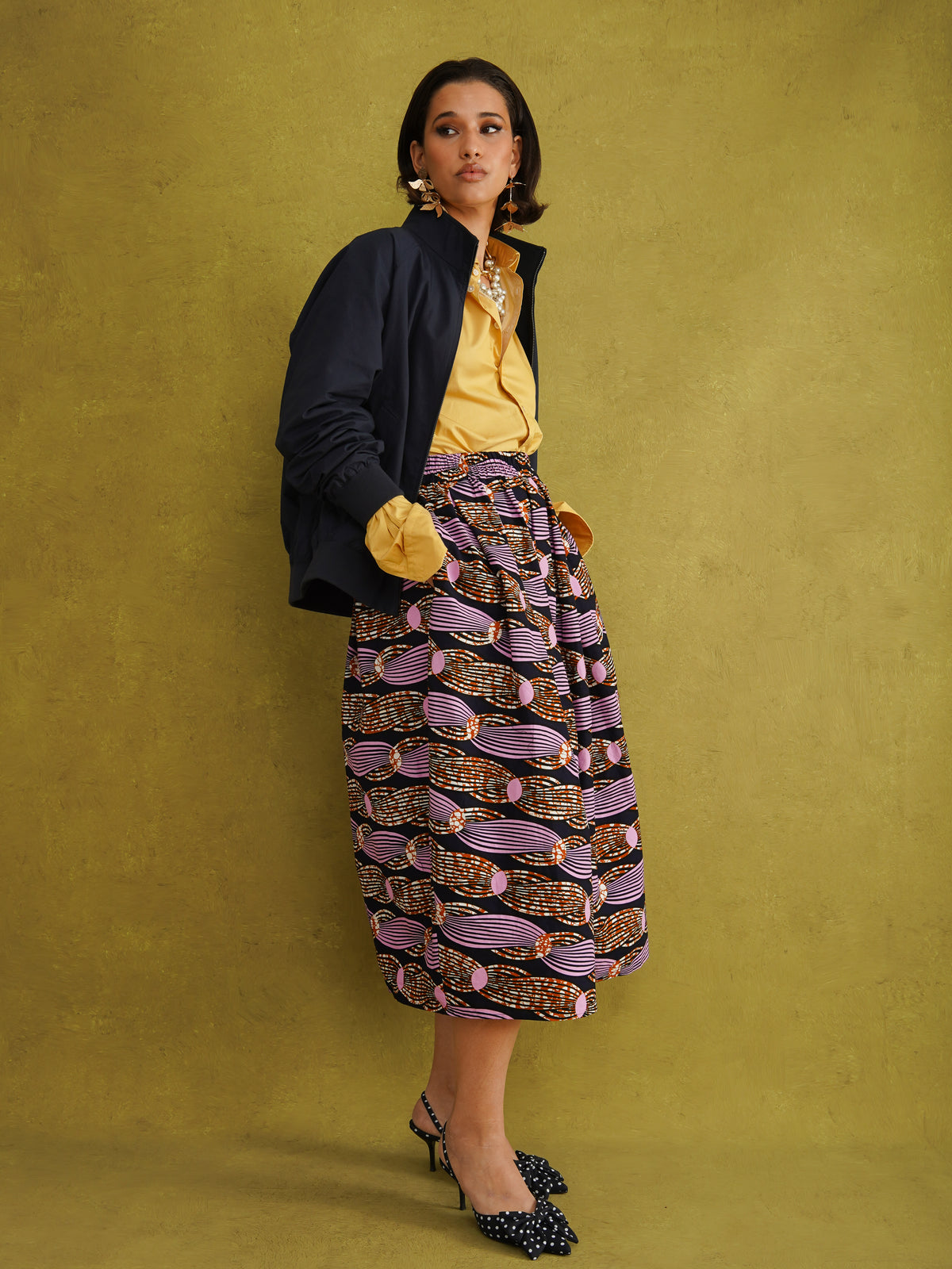 Irawo Cotton Midi Skirt, a tulip-shaped midi skirt in pink and orange shooting-star print Dutch wax cotton on a deep navy background