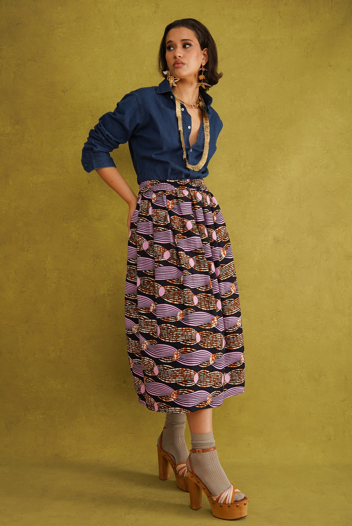 Irawo Cotton Midi Skirt, a tulip-shaped midi skirt in pink and orange shooting-star print Dutch wax cotton on a deep navy background