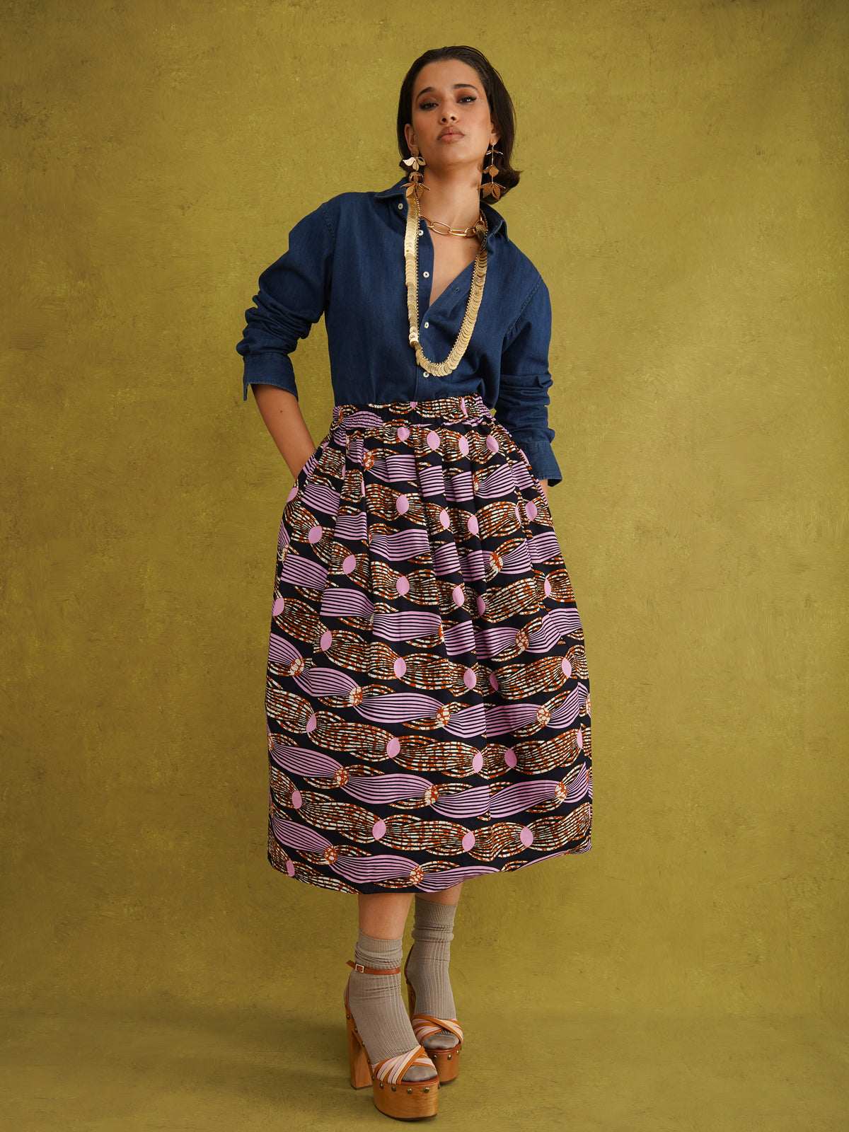 Irawo Cotton Midi Skirt, a tulip-shaped midi skirt in pink and orange shooting-star print Dutch wax cotton on a deep navy background