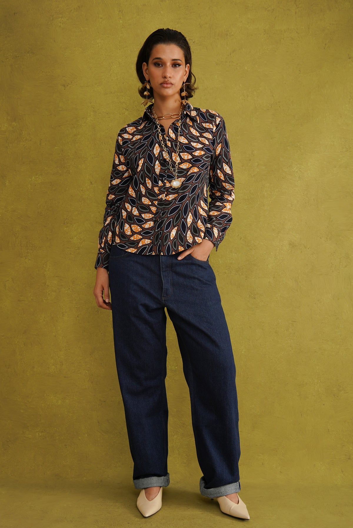 Eweko Adaze Shirt, a fitted shirt in deep navy and orange leaf print Dutch wax cotton on a warm brown background