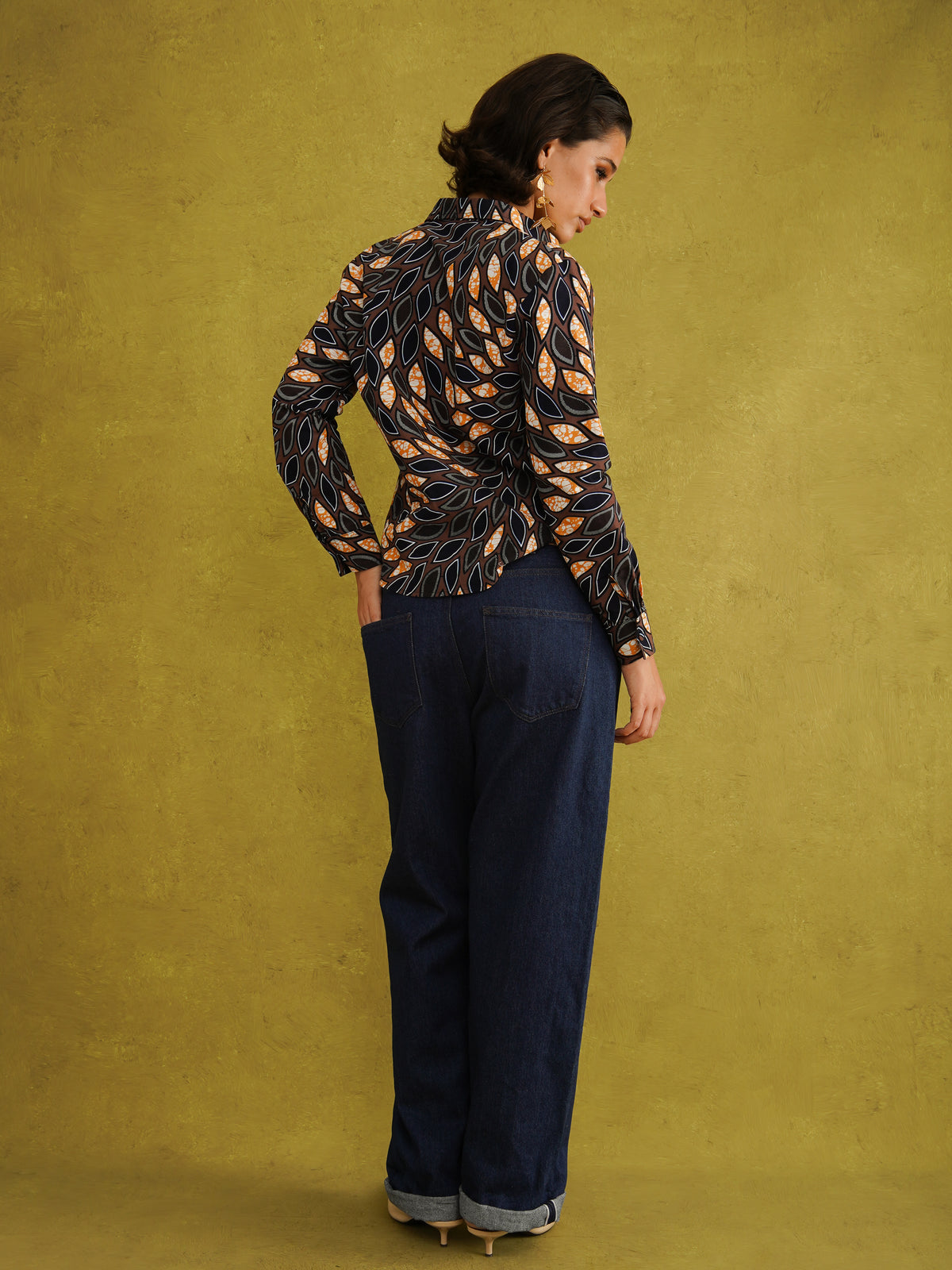 Eweko Adaze Shirt, a fitted shirt in deep navy and orange leaf print Dutch wax cotton on a warm brown background