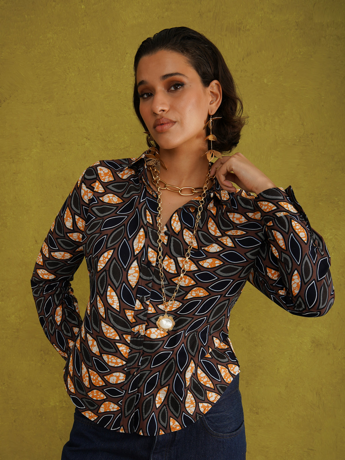 Eweko Adaze Shirt, a fitted shirt in deep navy and orange leaf print Dutch wax cotton on a warm brown background