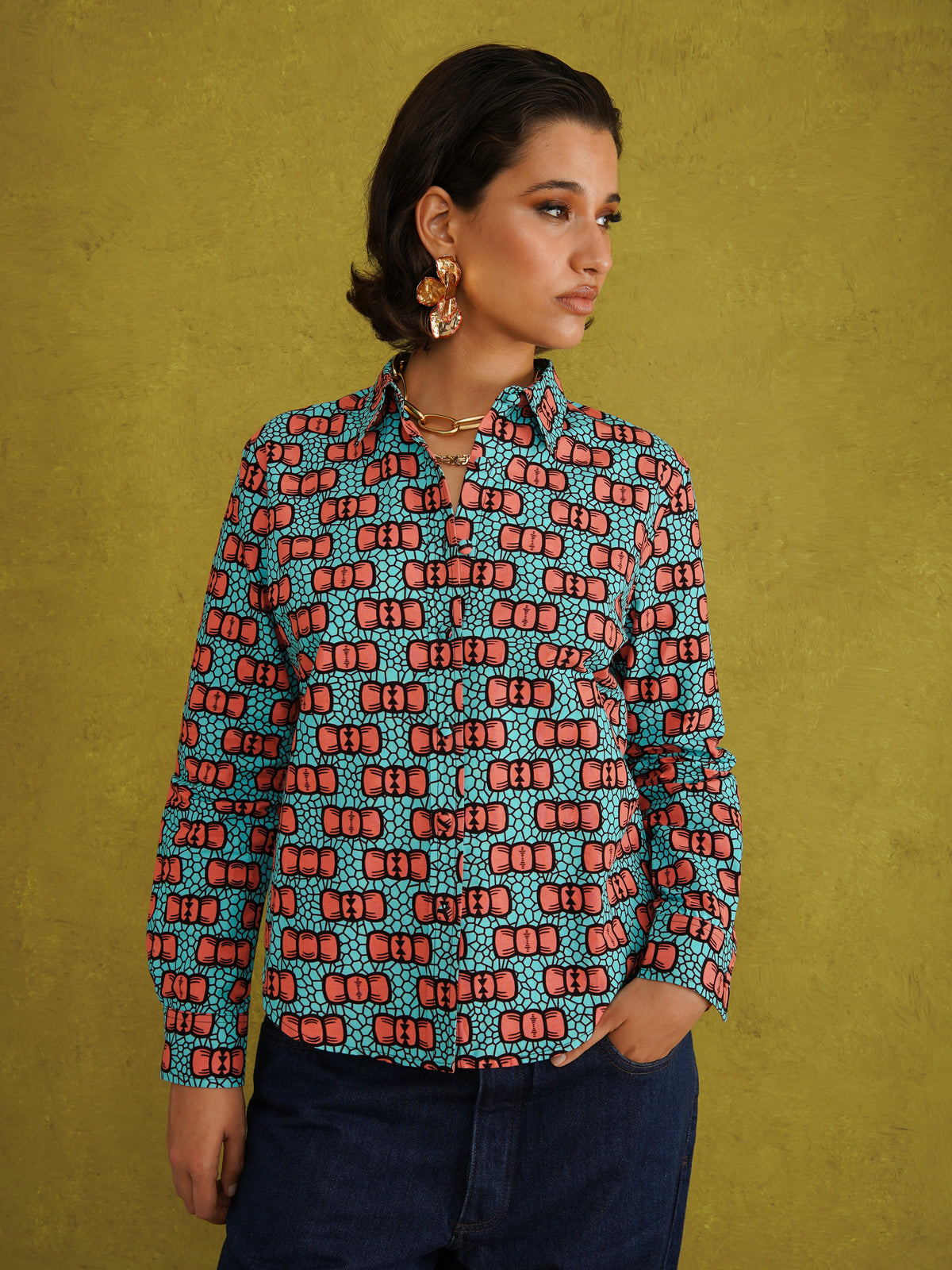 Oge Adaze Shirt, a fitted shirt in Dutch wax cotton with coral-pink bows on a bright turquoise background