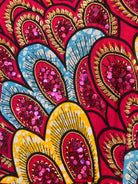 Close-up of hand-beaded detail – sequins and beads in pink and gold on African wax fabric.