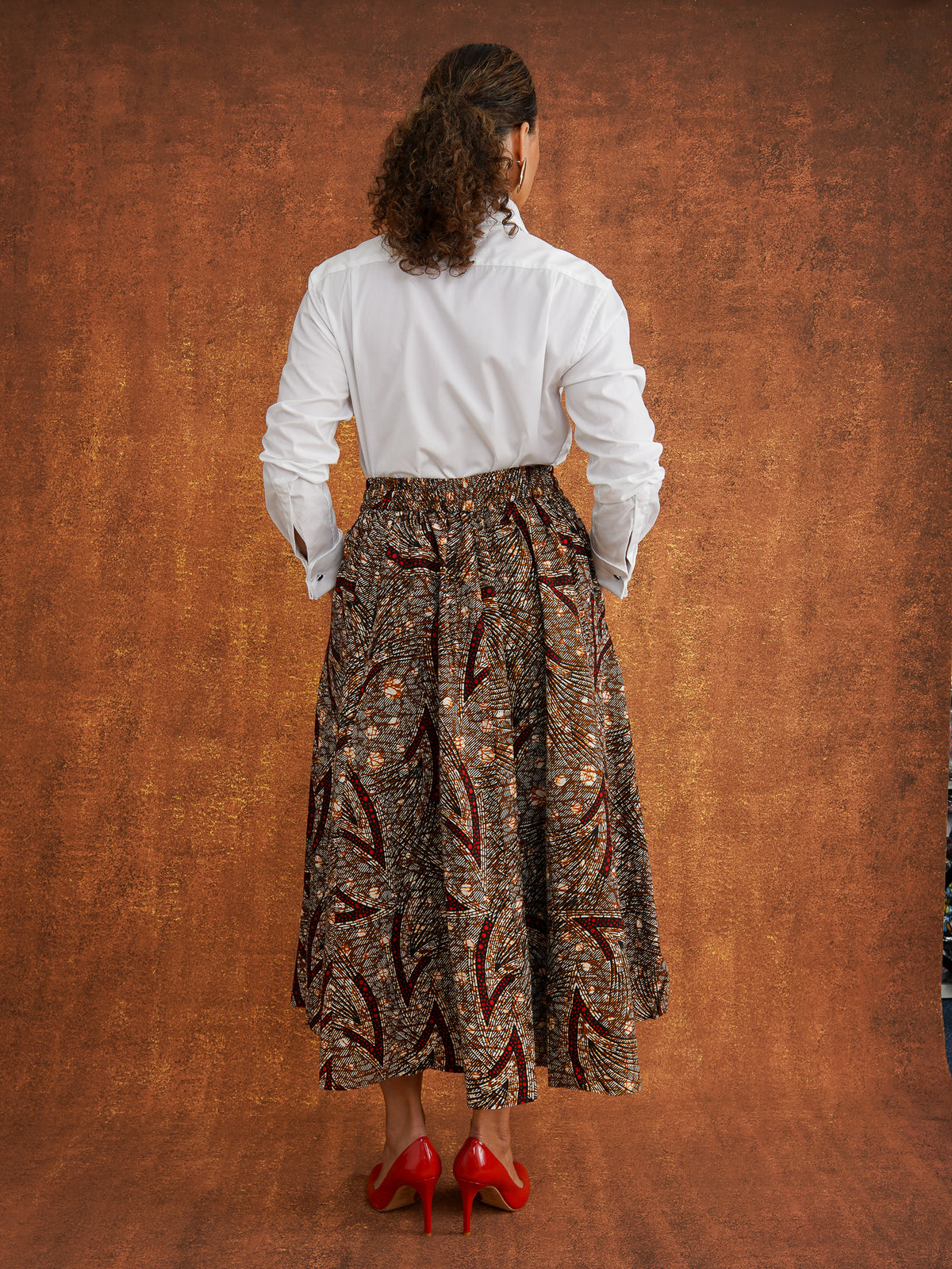Back view of the Chinaza Dutch wax cotton midi skirt worn with a white shirt