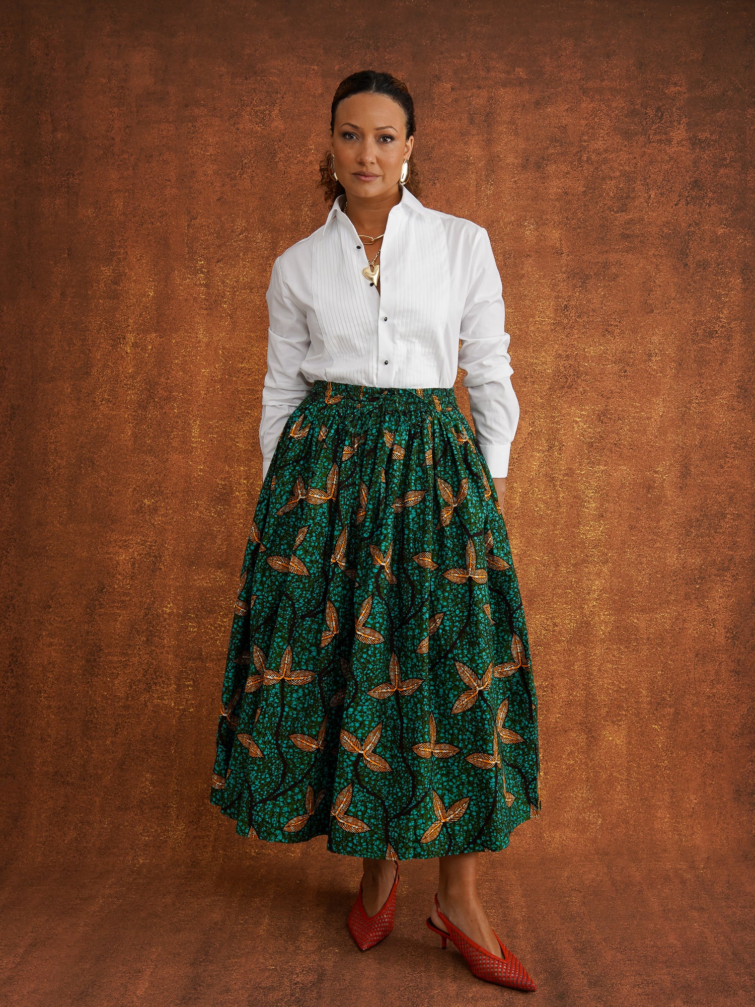 Front view of Tanna green Dutch wax cotton skirt styled with a tucked-in white shirt