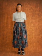 Full outfit view of the KemKem Abstract Midi Skirt with a pale blue knit, dark socks and heels