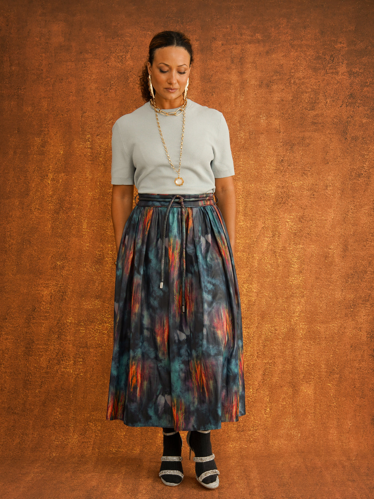 Full outfit view of the KemKem Abstract Midi Skirt with a pale blue knit, dark socks and heels