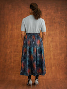 Back view of the KemKem Abstract Midi Skirt styled with a pale blue knit and dark socks