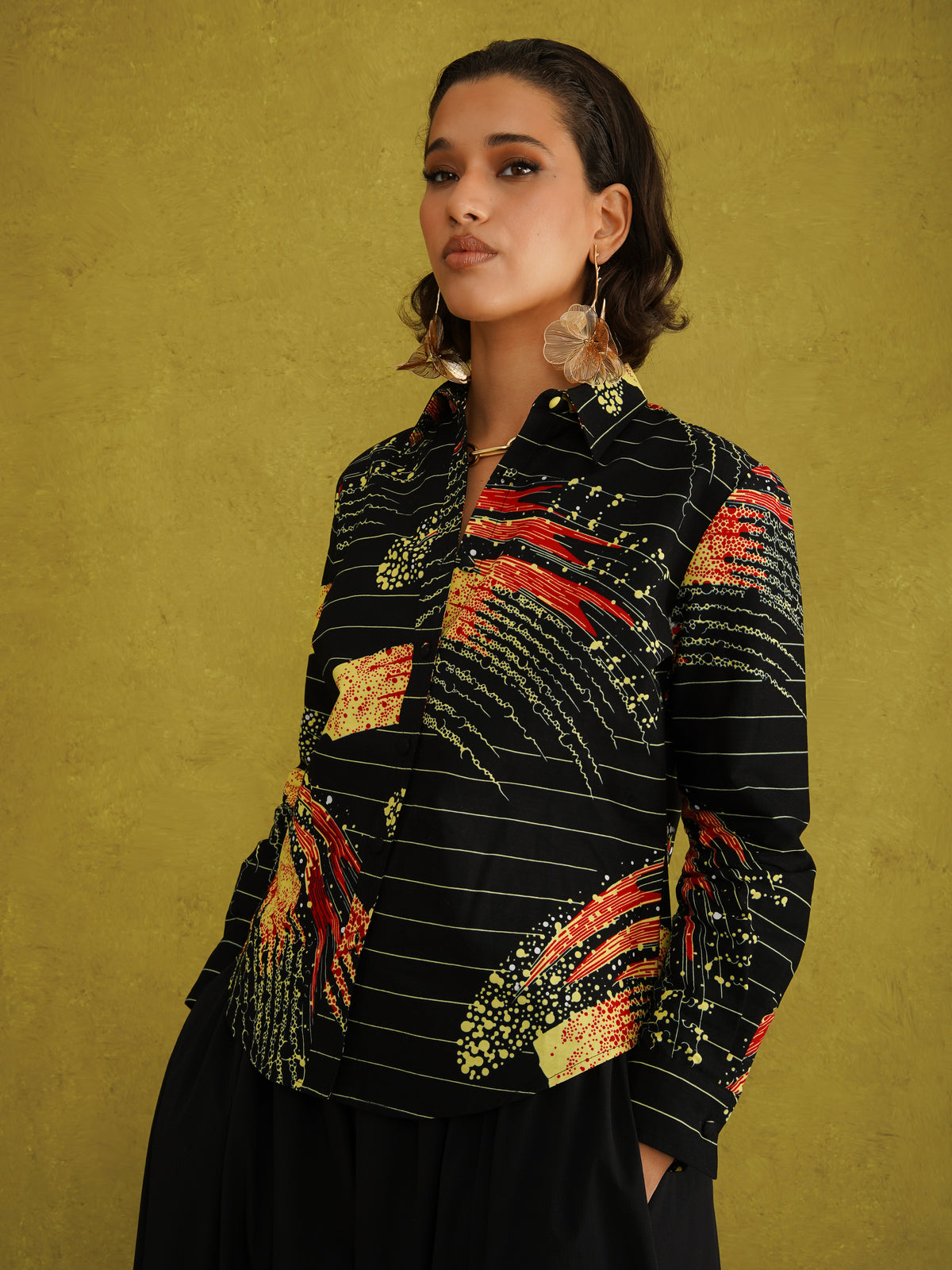 Ariya Adaze Shirt, a fitted shirt in red and yellow Fireworks print Dutch wax cotton on a blue background