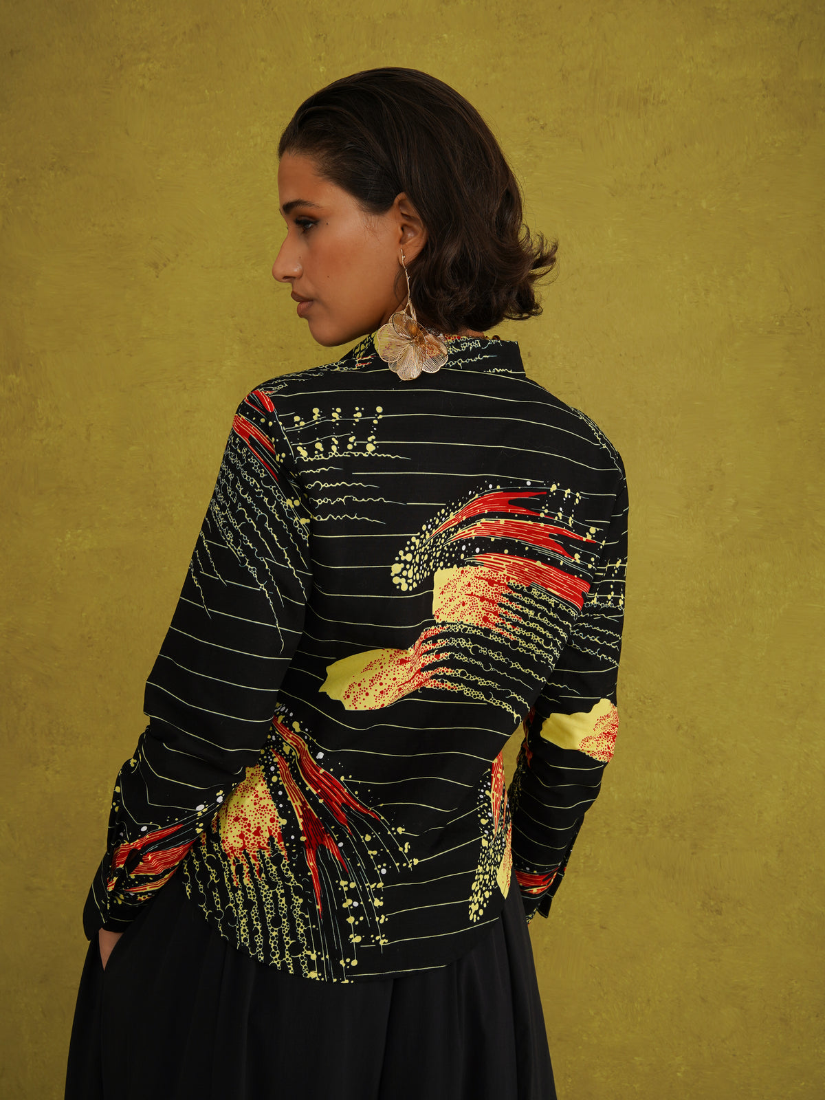 Ariya Adaze Shirt, a fitted shirt in red and yellow Fireworks print Dutch wax cotton on a blue background