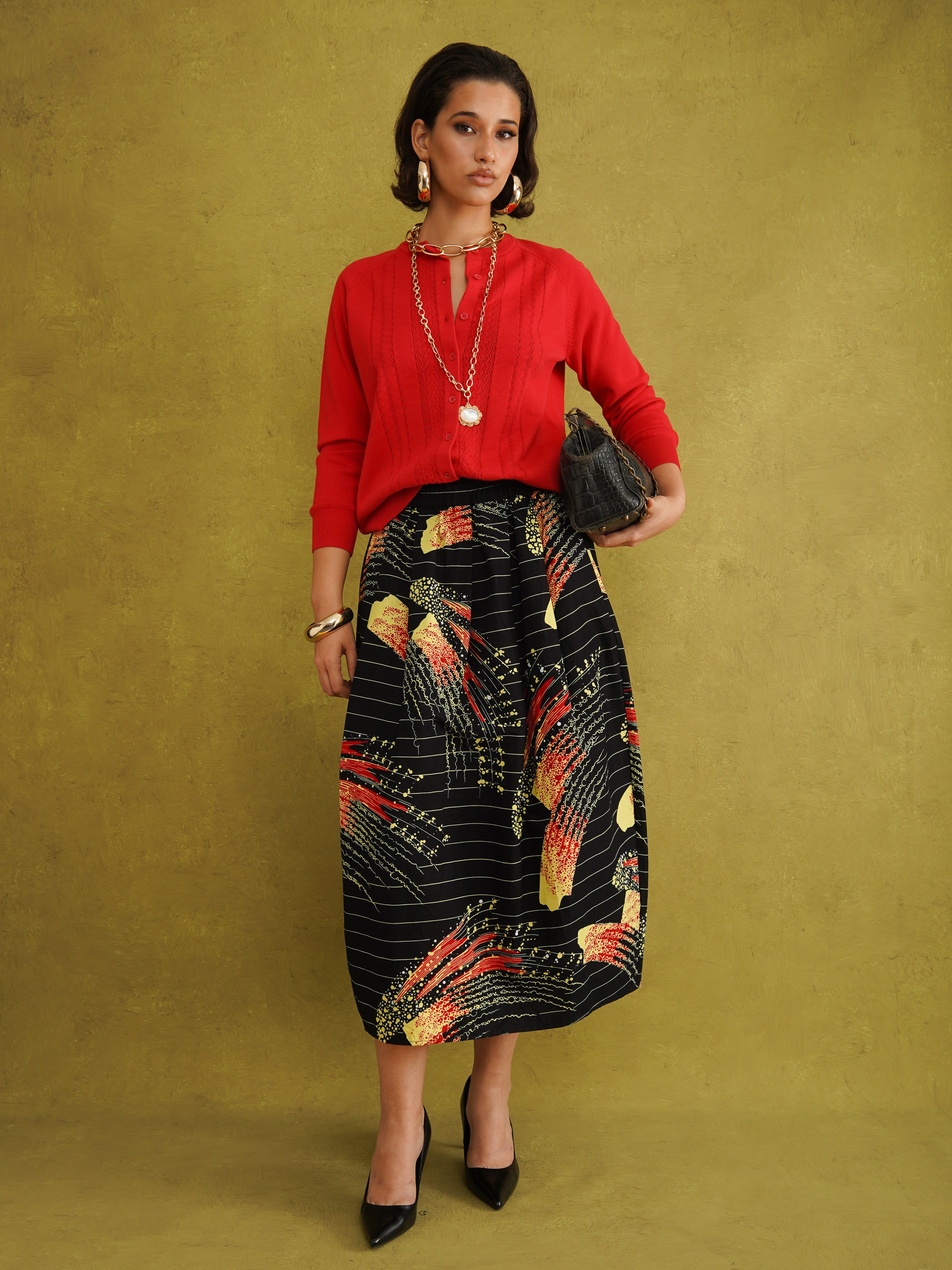 Titi Cardigan in Red, a relaxed-fit red knit cardigan with open-work and cable stitches and small buttons up to the neck