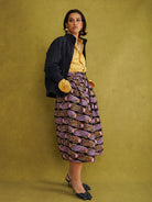 Irawo Cotton Midi Skirt, a tulip-shaped midi skirt in pink and orange shooting-star print Dutch wax cotton on a deep navy background