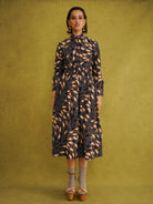 Eweko Adaze Shirt, a fitted shirt in deep navy and orange leaf print Dutch wax cotton on a warm brown background