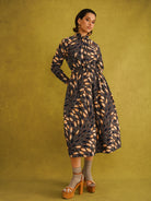 Eweko Cotton Midi Skirt, a tulip-shaped midi skirt in deep navy and orange leaf print Dutch wax cotton on a warm brown background