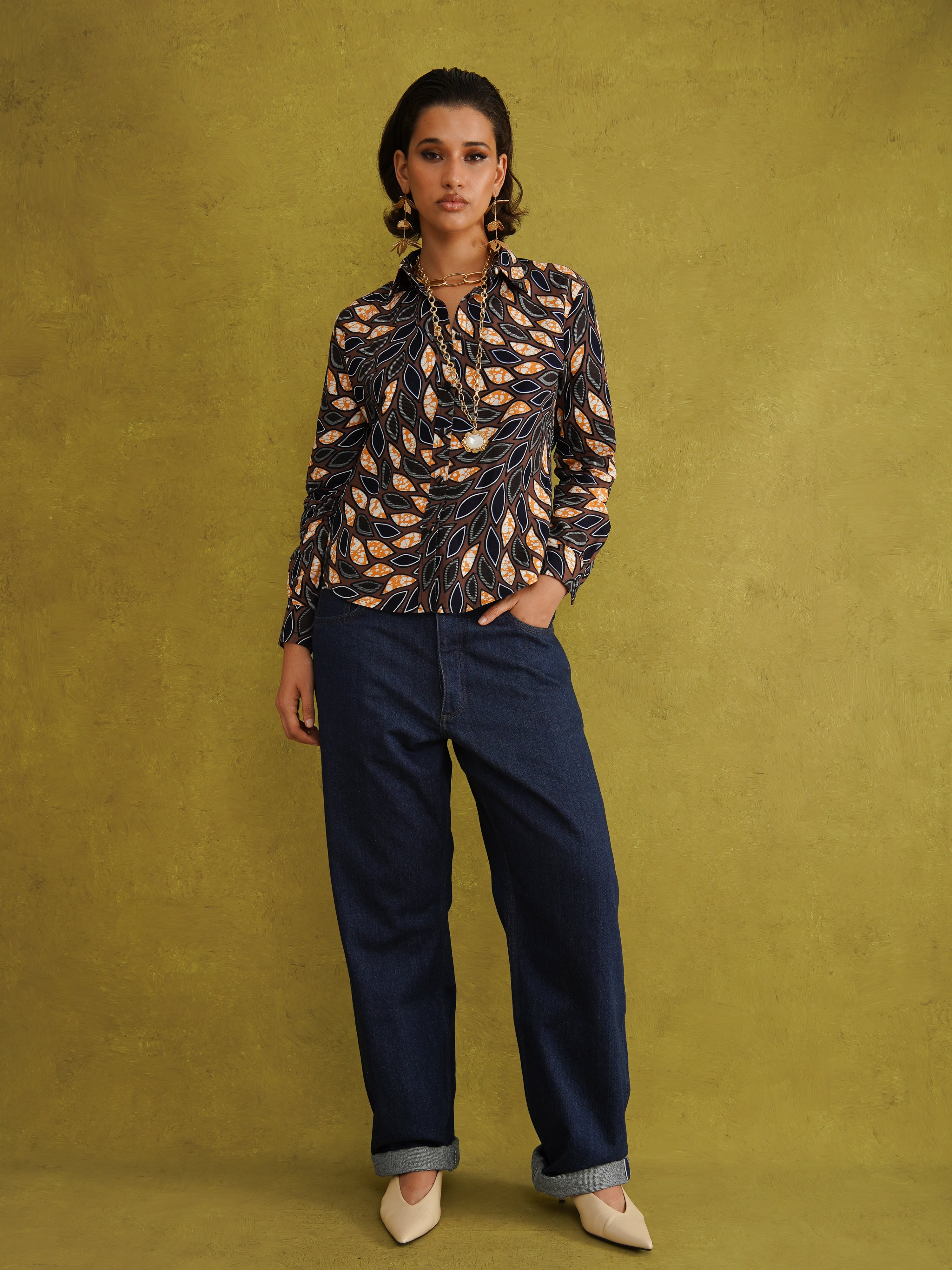 Eweko Adaze Shirt, a fitted shirt in deep navy and orange leaf print Dutch wax cotton on a warm brown background