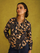 Eweko Adaze Shirt, a fitted shirt in deep navy and orange leaf print Dutch wax cotton on a warm brown background