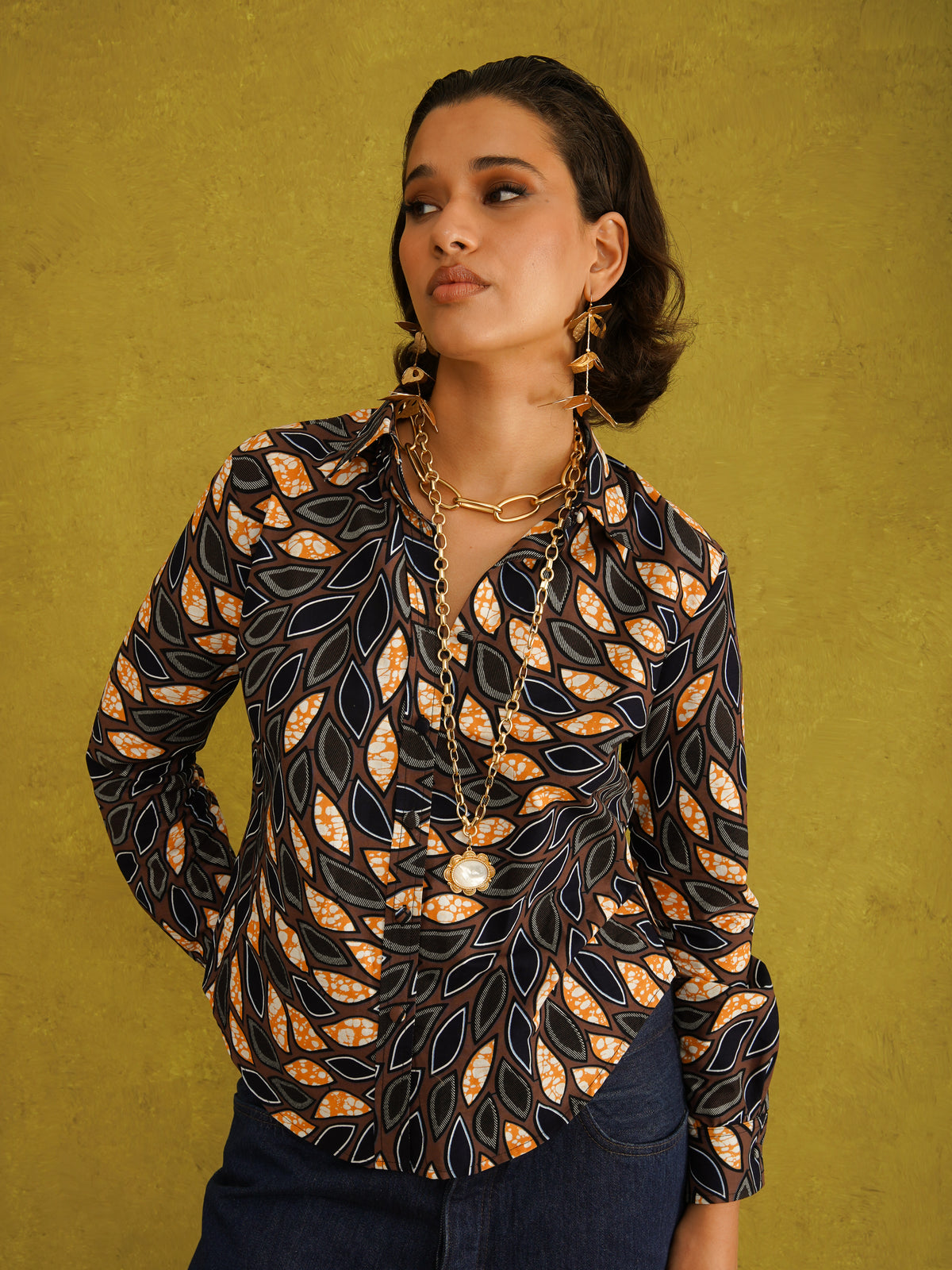 Eweko Adaze Shirt, a fitted shirt in deep navy and orange leaf print Dutch wax cotton on a warm brown background