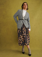Eweko Cotton Midi Skirt, a tulip-shaped midi skirt in deep navy and orange leaf print Dutch wax cotton on a warm brown background