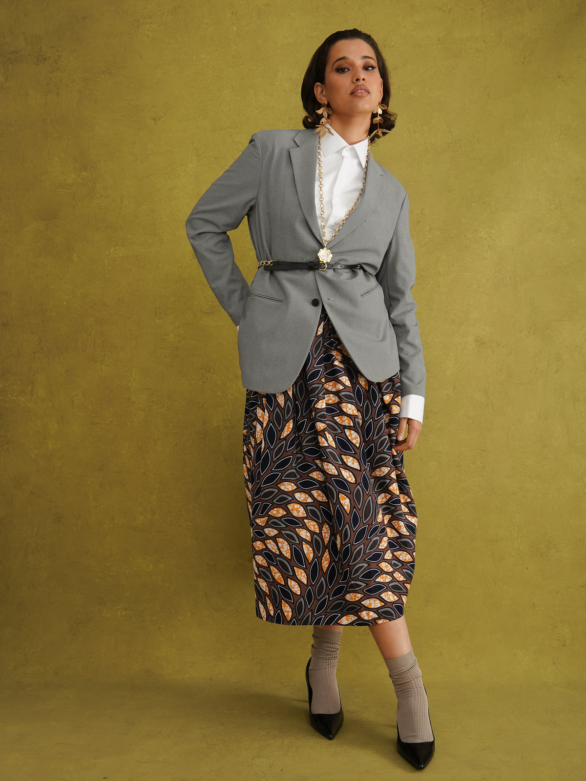 Eweko Cotton Midi Skirt, a tulip-shaped midi skirt in deep navy and orange leaf print Dutch wax cotton on a warm brown background