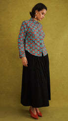 Oge Adaze Shirt, a fitted shirt in Dutch wax cotton with coral-pink bows on a bright turquoise background