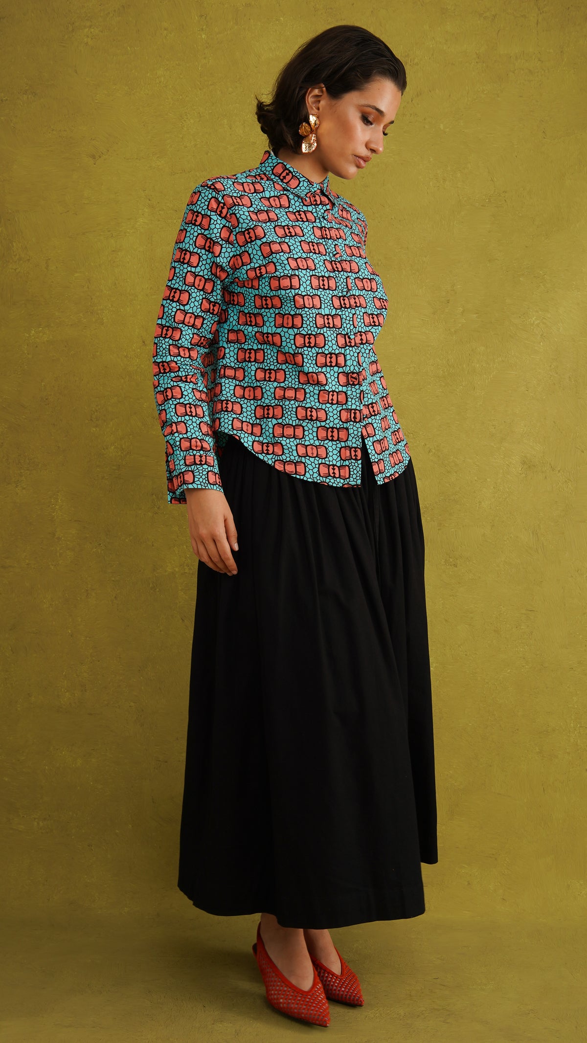Oge Adaze Shirt, a fitted shirt in Dutch wax cotton with coral-pink bows on a bright turquoise background