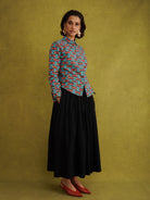 Oge Adaze Shirt, a fitted shirt in Dutch wax cotton with coral-pink bows on a bright turquoise background