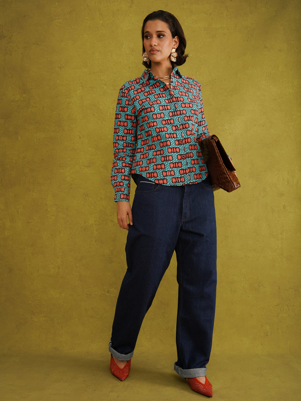 Oge Adaze Shirt, a fitted shirt in Dutch wax cotton with coral-pink bows on a bright turquoise background