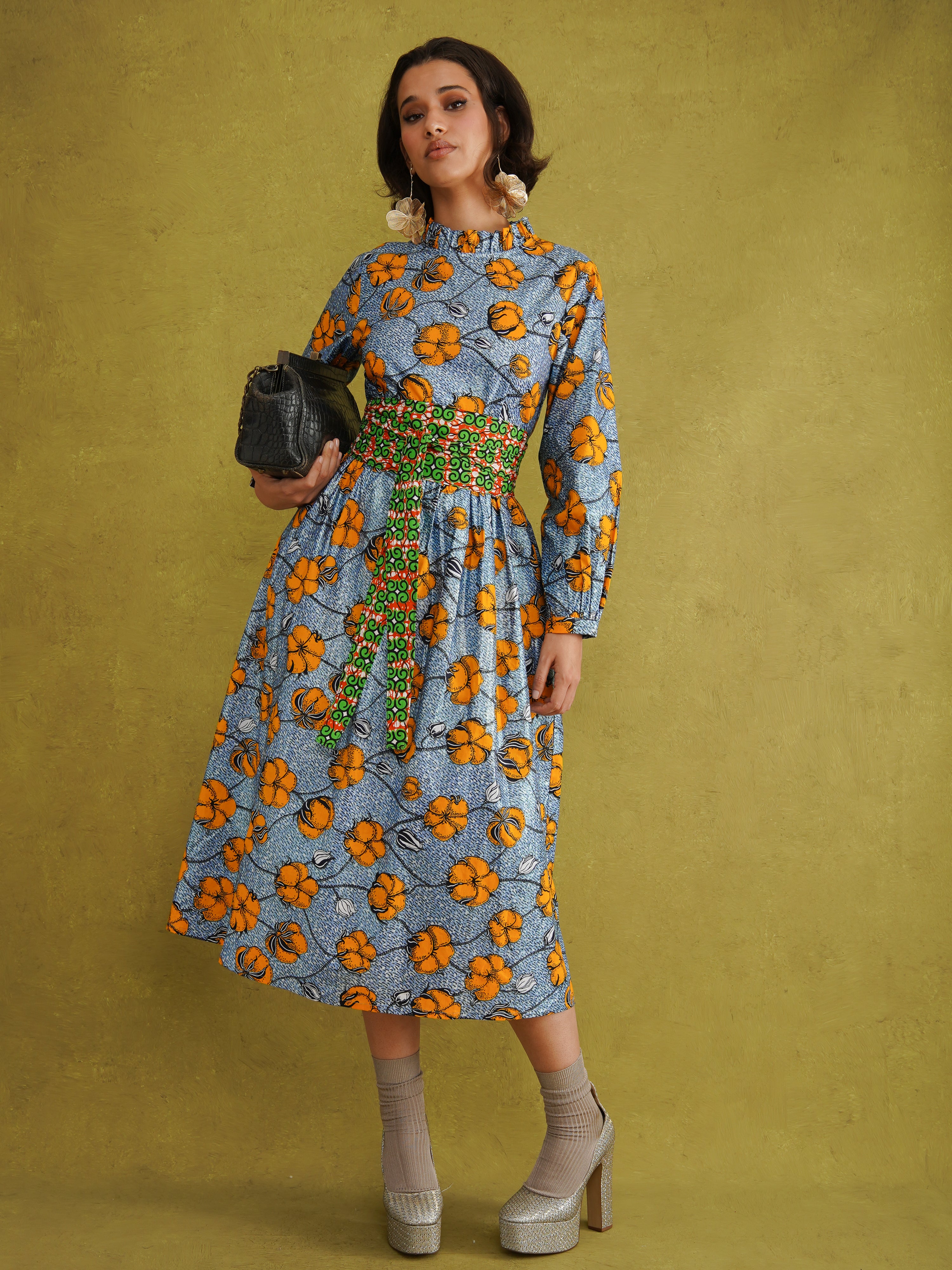 Commot for Road Blue Glittery Dress by Kemi Telford, a blue and orange floral wax print dress with a high ruffle neck and balloon sleeves